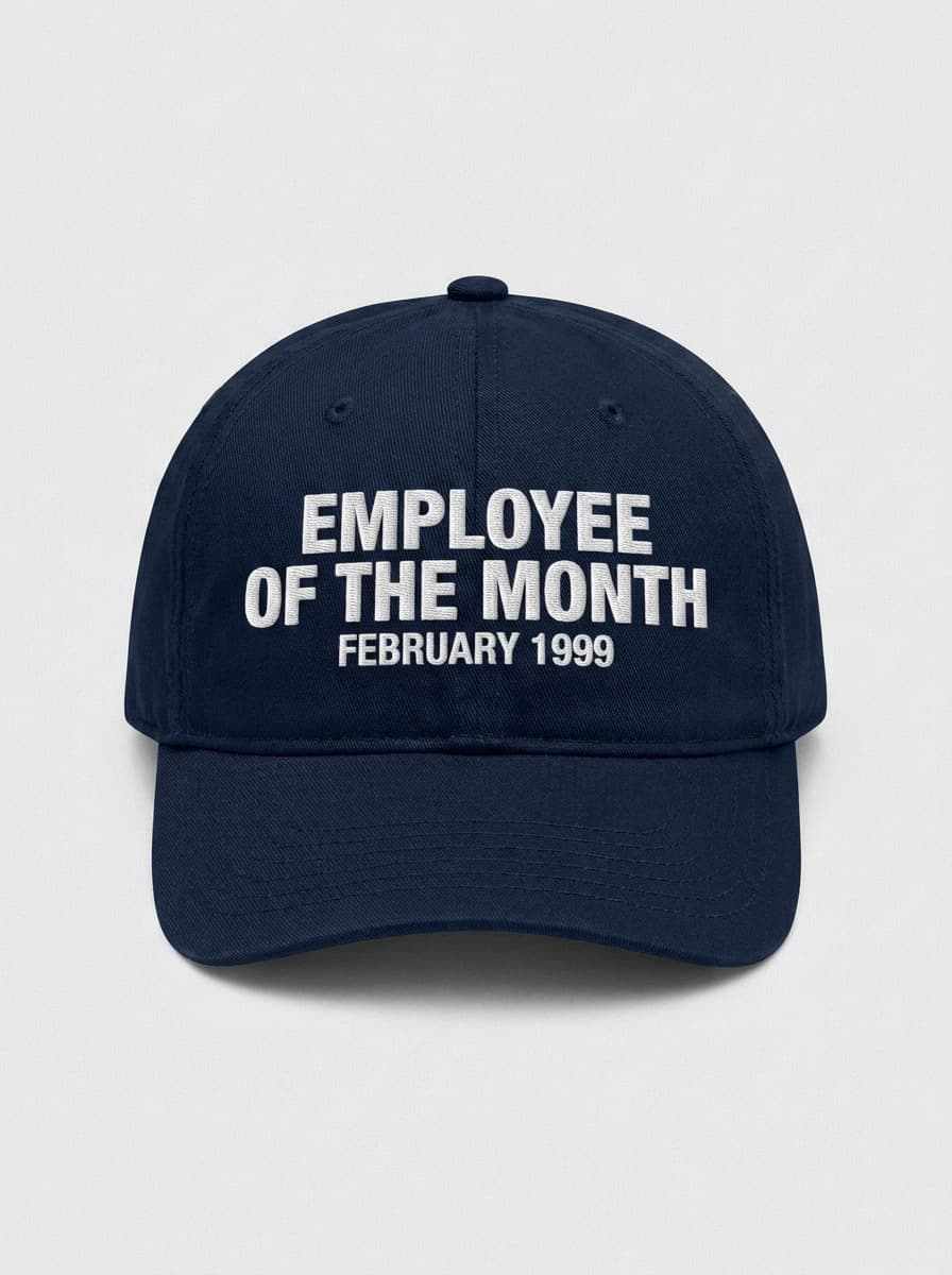 Navy dad hat embroidered in white with EMPLOYEE OF THE MONTH above FEBRUARY 1999.