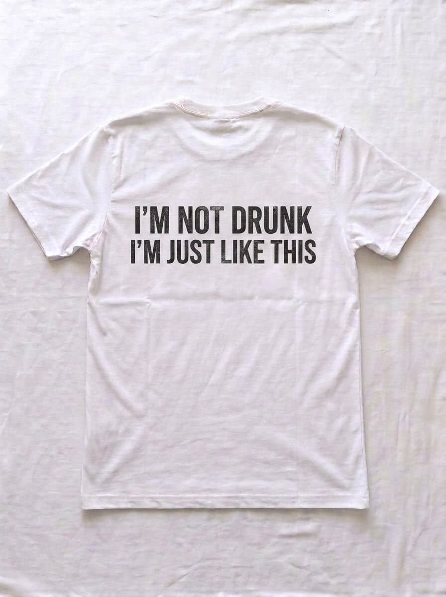 Back of a white t-shirt printed in distressed black type with I'M NOT DRUNK I'M JUST LIKE THIS.