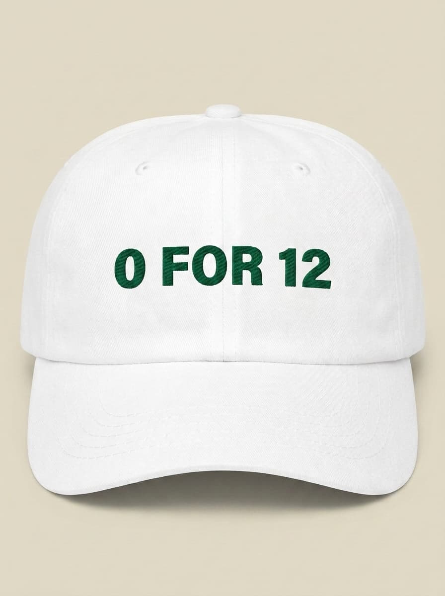 White dad hat embroidered in dark green with 0 FOR 12.