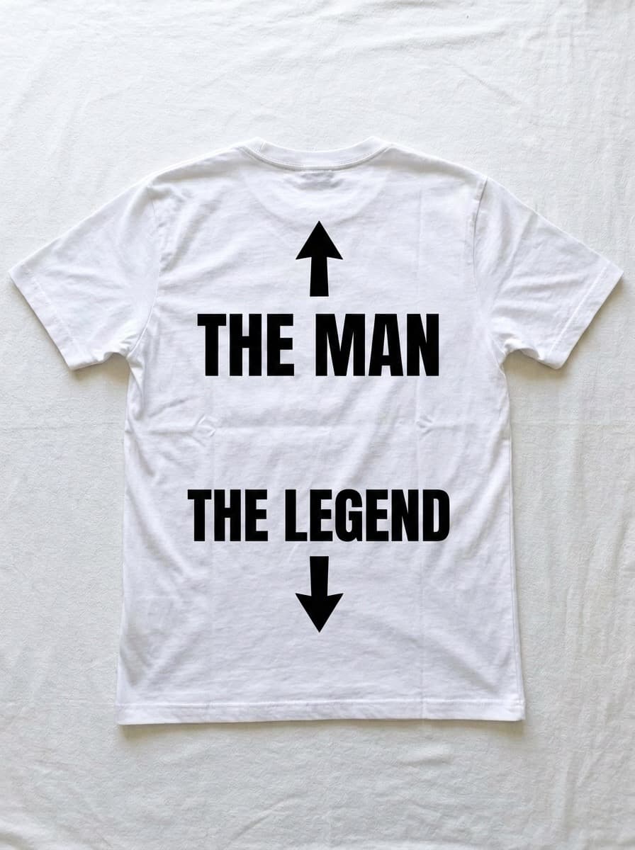 Back of a white t-shirt printed with an arrow pointing up above the words THE MAN, and the words THE LEGEND above an arrow pointing down.